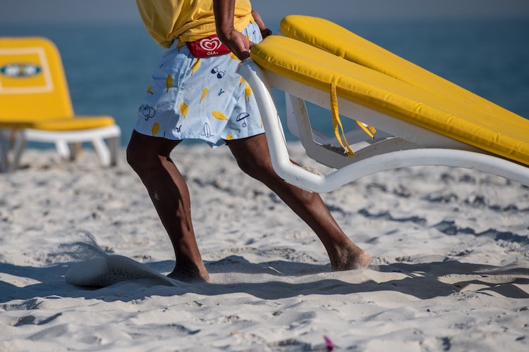 Moving beach chairs on Cape Town beach.